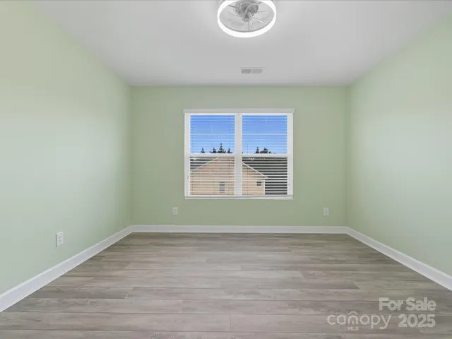a view of room with window and wooden floor