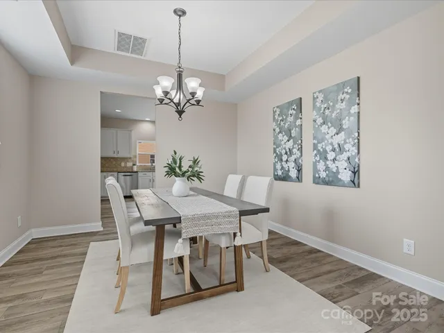 a view of a dining room with furniture a chandelier and wooden floor