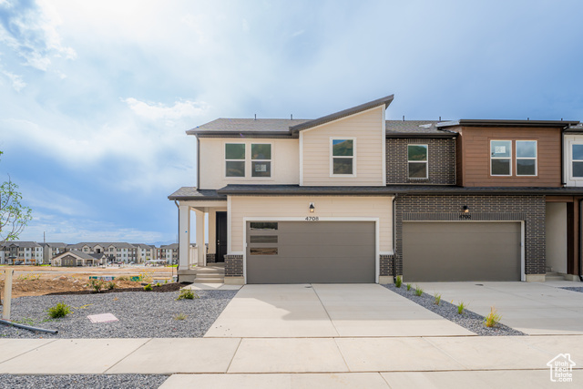 View of front facade featuring concrete driveway, a residential view, an attached garage, a porch, and roof with shingles