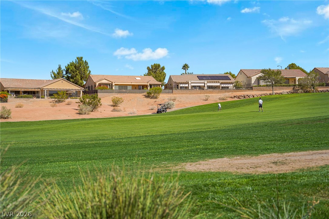 2738 Grand Forks Road Henderson, NV 89052 - Photo 36 of 52 Lush fairways stretch out behind single-story neighborhood homes under a blue sky.