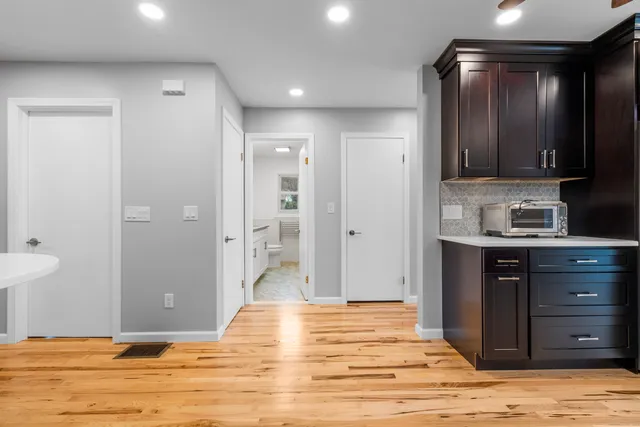 a bathroom with a granite countertop sink a toilet a shower and a mirror