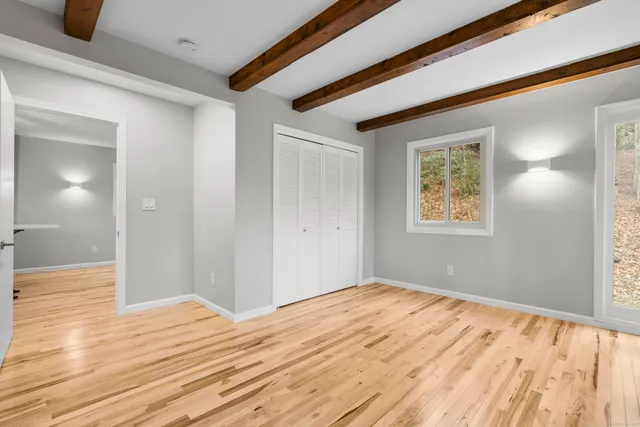 a view of empty room with wooden floor and fireplace