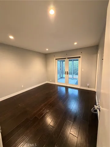 an empty room with wooden floor and entrance