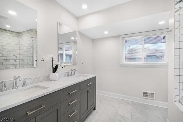 a bathroom with double vanity sink and a mirror