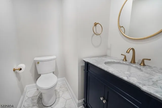 a bathroom with a granite countertop toilet sink and mirror