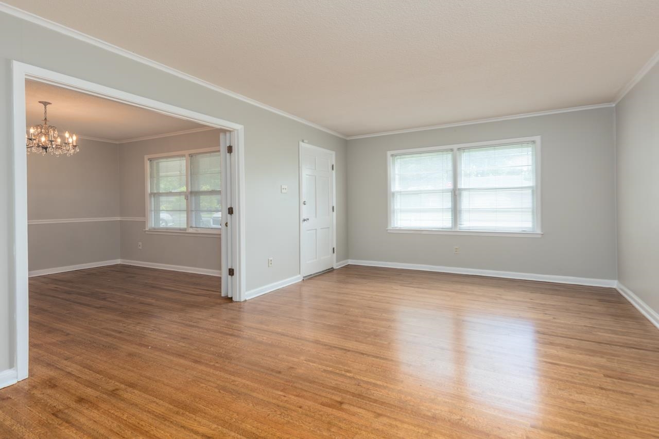 4888 Dee Road Memphis, TN 38117 - Photo 3 of 18 an empty room with wooden floor and windows