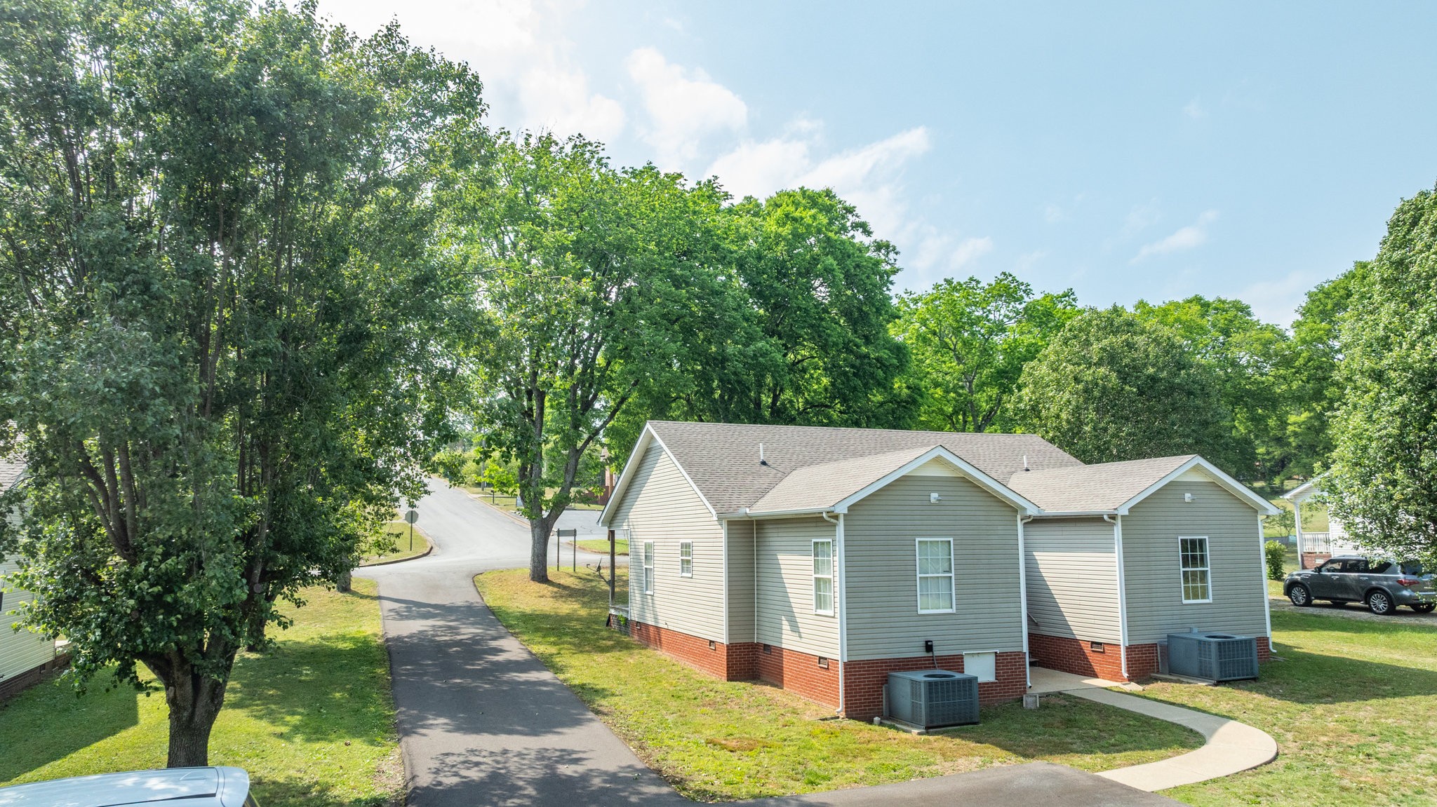 225 Locust Street Pulaski, TN 38478 - Photo 4 of 44 a view of a big house with a big yard potted plants and large tree