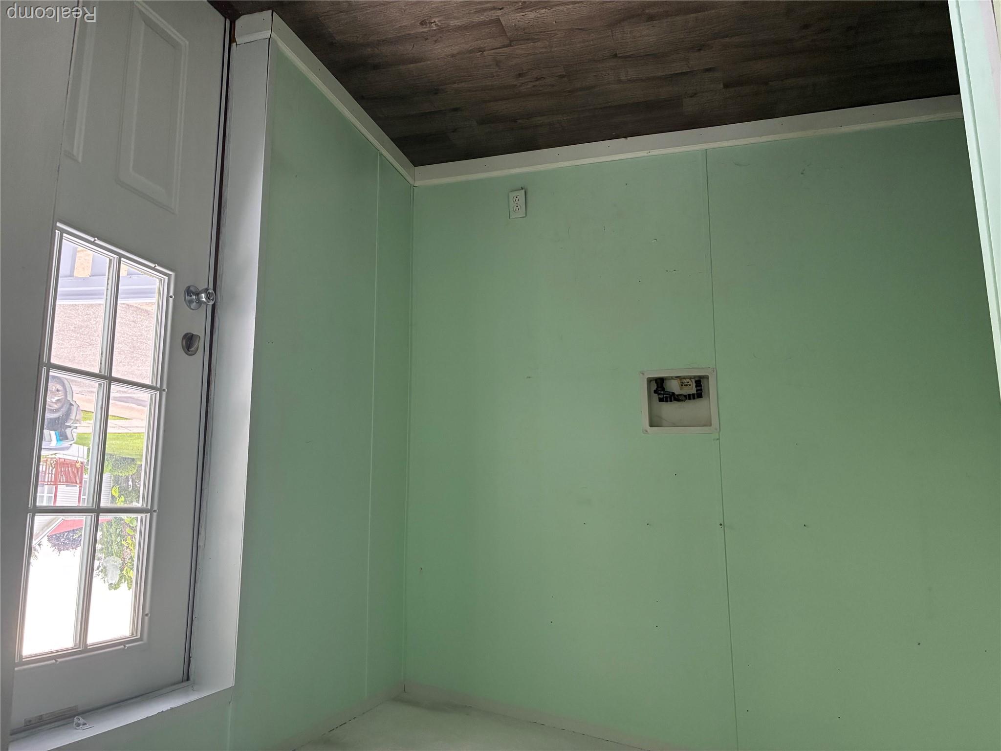 7364 Kings Court Alma, MI 48801 - Photo 12 of 16 Utility room featuring wood-finish flooring and a white paneled exterior door with multiple glass panes