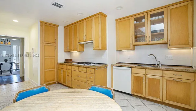a kitchen with stainless steel appliances granite countertop a sink cabinets and wooden floor