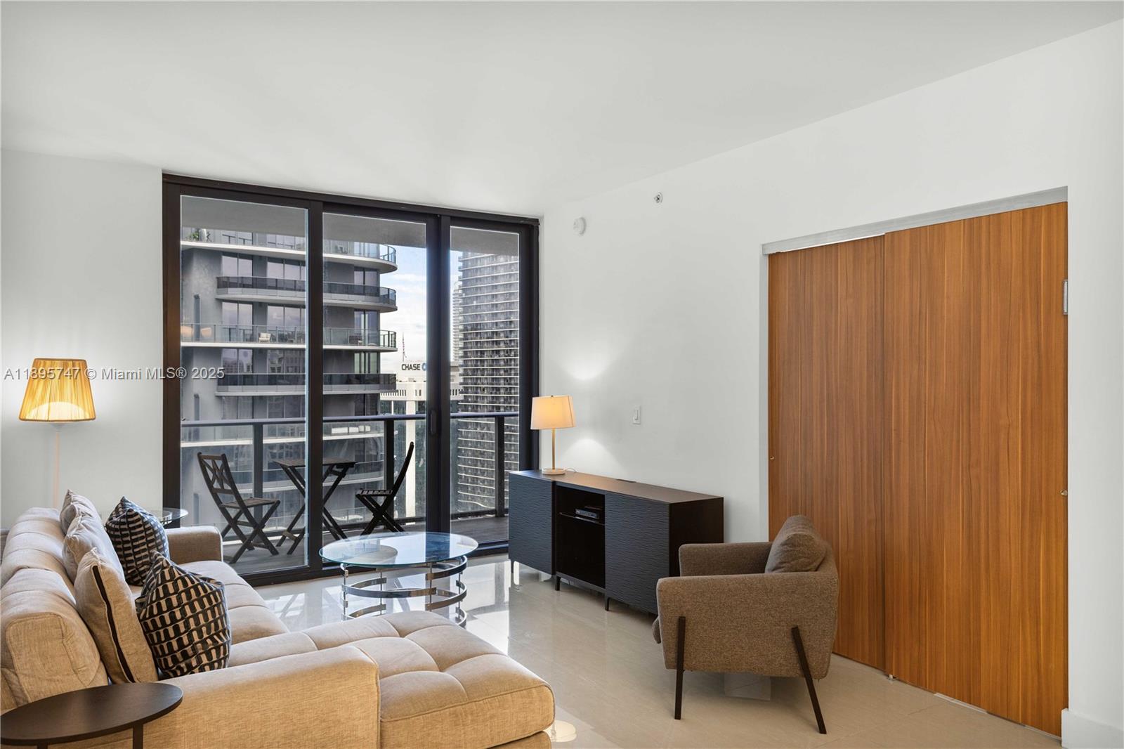 1010 Brickell Avenue, Unit 3208 Miami, FL 33131 - Photo 3 of 15 a living room with furniture and a window