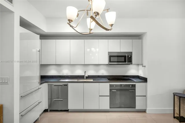 a kitchen with granite countertop a sink cabinets and stainless steel appliances