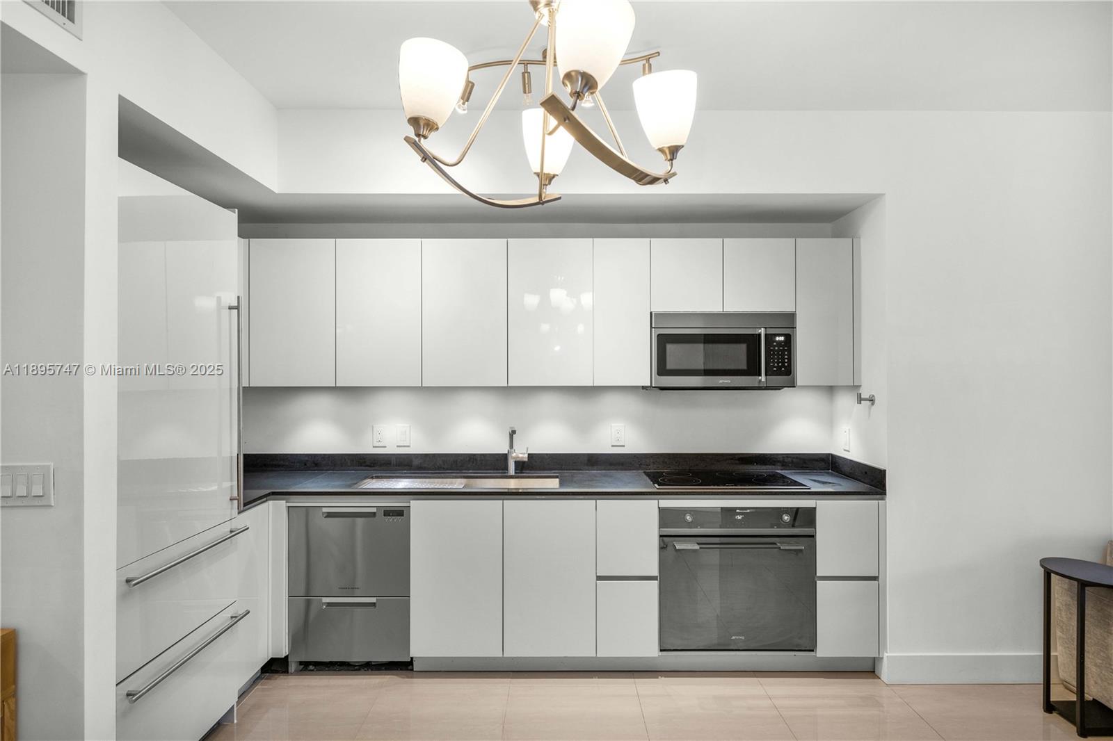 1010 Brickell Avenue, Unit 3208 Miami, FL 33131 - Photo 7 of 15 a kitchen with granite countertop a sink cabinets and stainless steel appliances