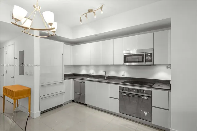 a kitchen with kitchen island granite countertop cabinets and stainless steel appliances
