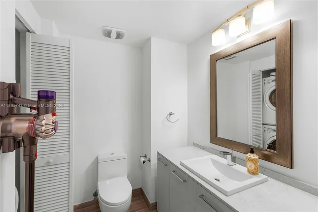 a bathroom with a sink vanity mirror and toilet