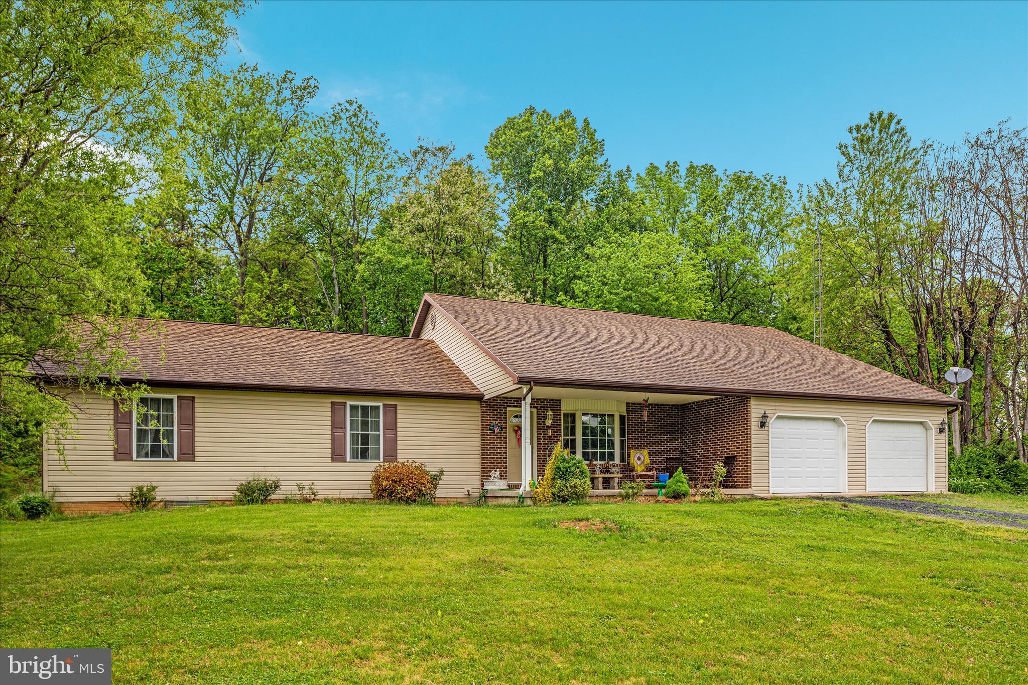 205 Clyde Borum Road Inwood, WV 25428 - Photo 2 of 46 a front view of a house with a garden