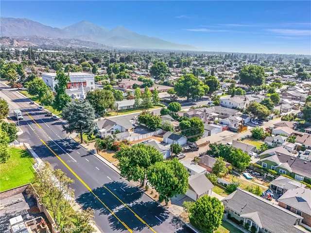 an aerial view of residential houses with outdoor space and trees