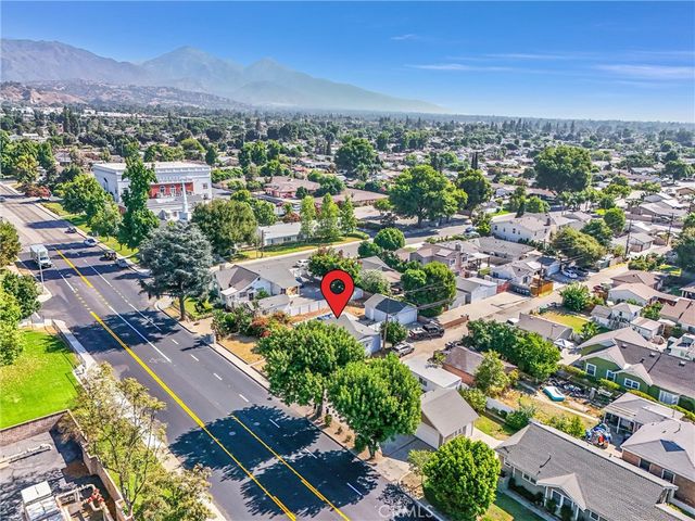 an aerial view of residential houses with outdoor space and trees