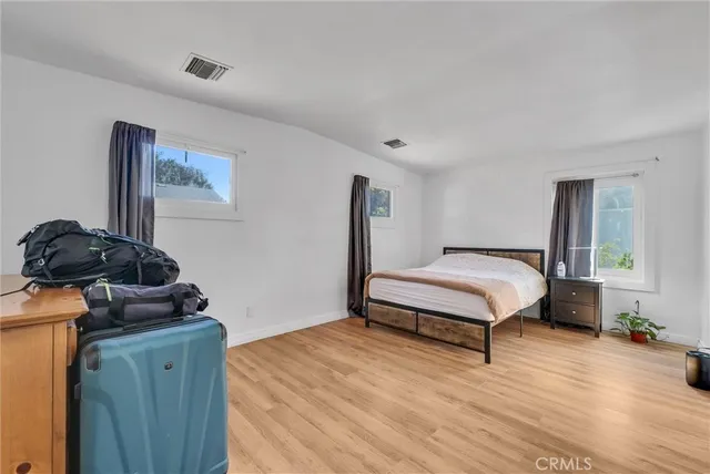 a bedroom with a bed and wooden floor