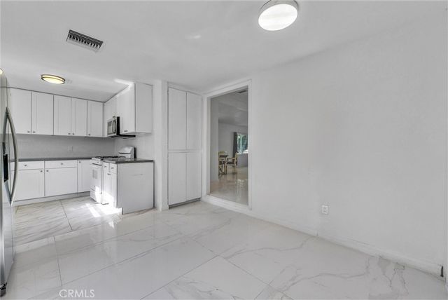 a kitchen with granite countertop a sink cabinets and stainless steel appliances