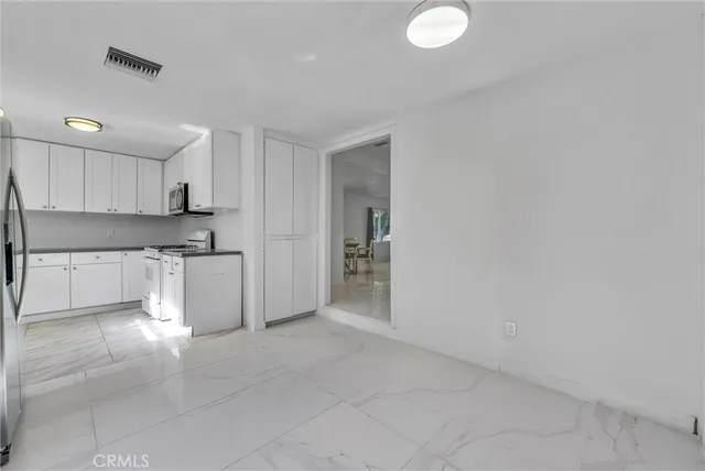 a kitchen with granite countertop a sink cabinets and stainless steel appliances
