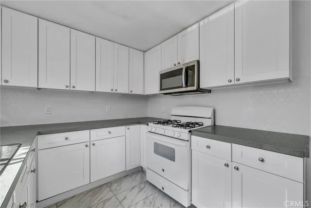 a kitchen with white cabinets and white appliances