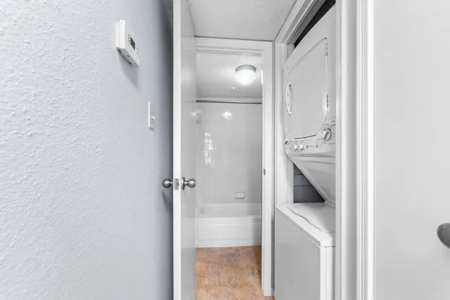 an empty room with wooden floor chandelier fan and windows