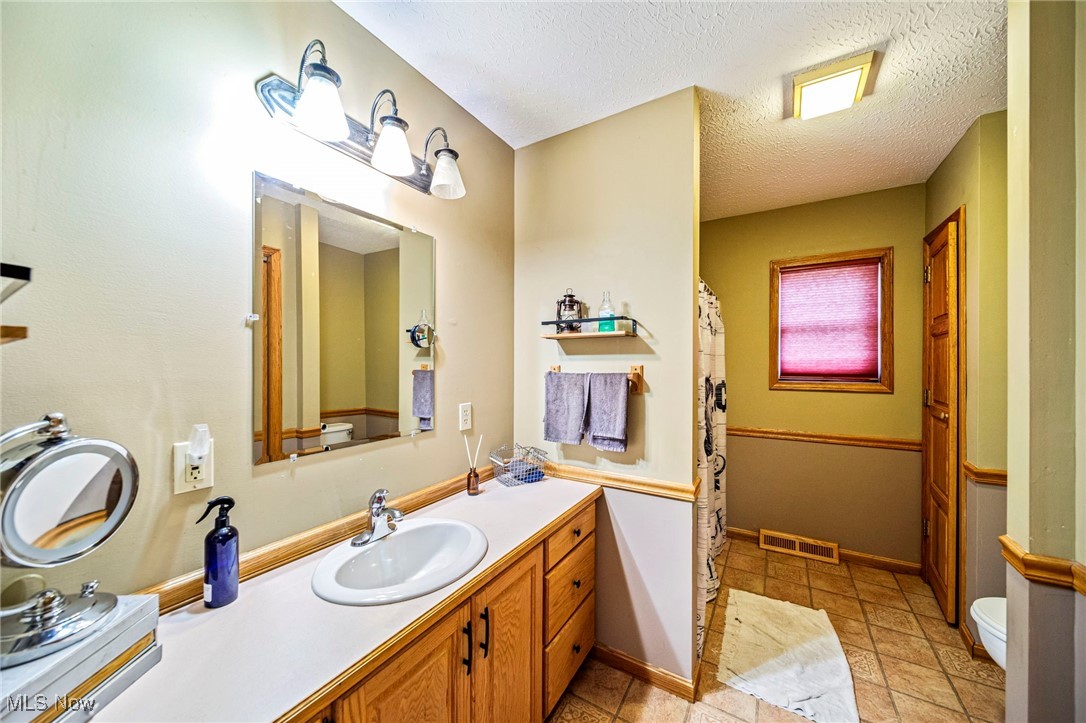 5050 Middle Road Conneaut, OH 44030 - Photo 27 of 35 Bathroom featuring vanity and a textured ceiling