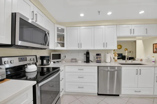 a kitchen with white cabinets and sink