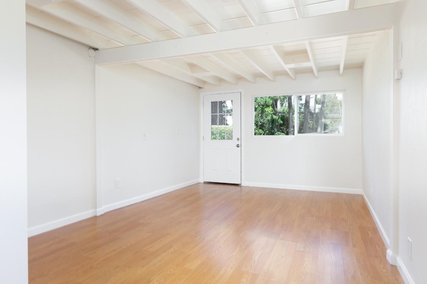 4138 Crest Road Pebble Beach, CA 93953 - Photo 25 of 38 an empty room with wooden floor and windows