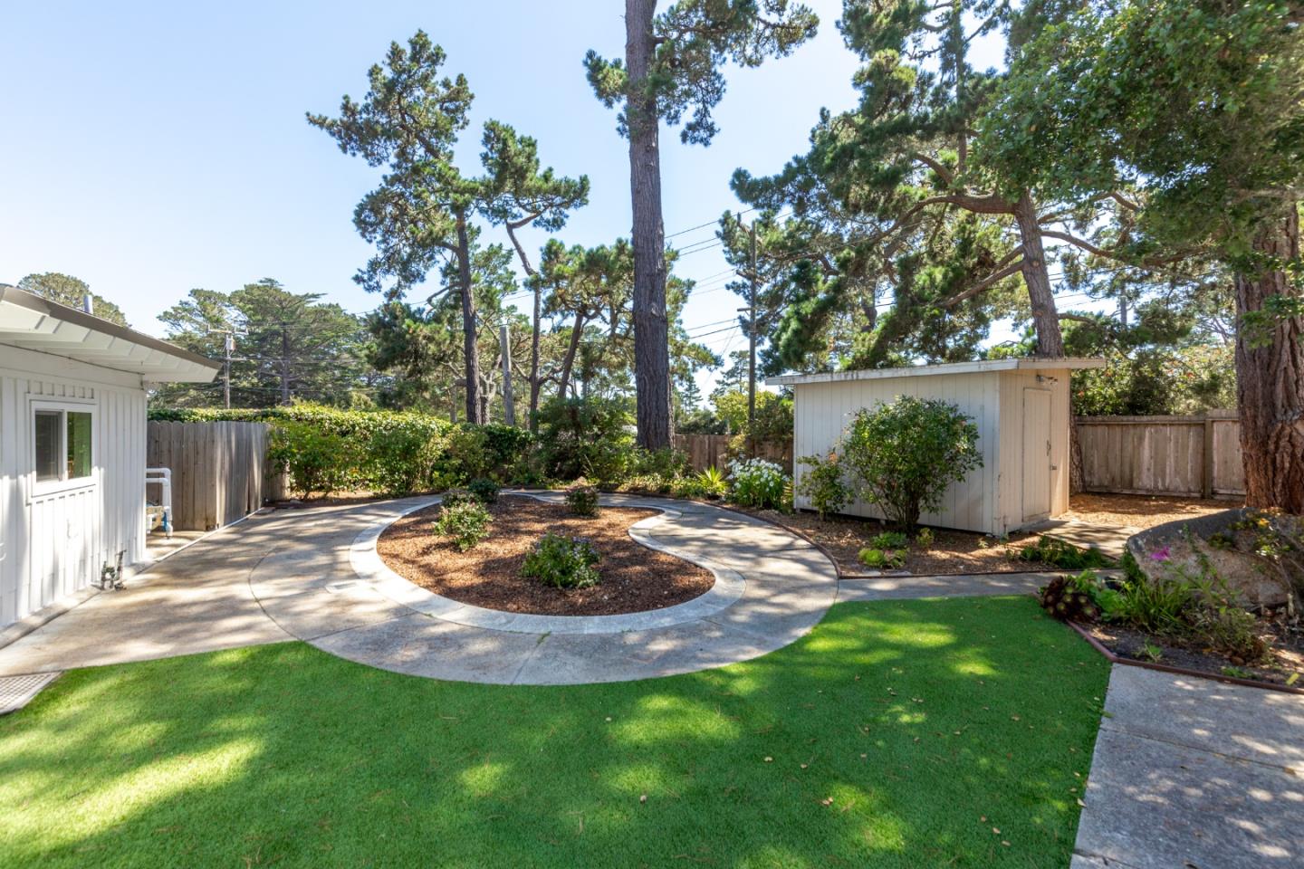 4138 Crest Road Pebble Beach, CA 93953 - Photo 31 of 38 a view of a backyard with table and chairs and wooden fence