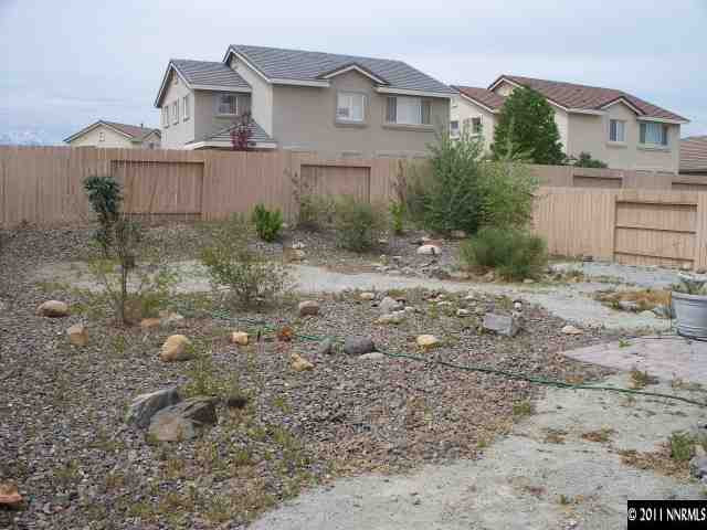 10065 Silver Star Drive Reno, NV 89521 - Photo 12 of 13 a view of a white house next to a yard
