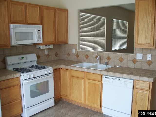 10065 Silver Star Drive Reno, NV 89521 - Photo 5 of 13 a kitchen with granite countertop a sink stove top oven and cabinets