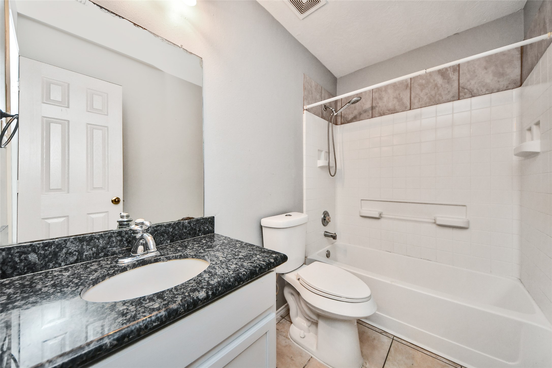 24019 Kingbriar Drive Spring, TX 77373 - Photo 23 of 41 The well-appointed bathroom includes a sleek vanity with a granite-style countertop, updated fixtures, and a clean tub-and-shower combination with classic tile surrounds.