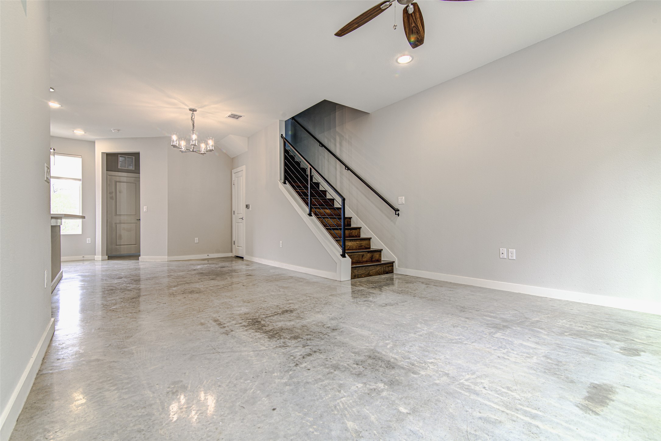 1904 Bunche Road, Unit B Austin, TX 78721 - Photo 3 of 29 Open living and dining area with polished concrete floors, modern lighting, and a flexible layout for relaxing or entertaining.