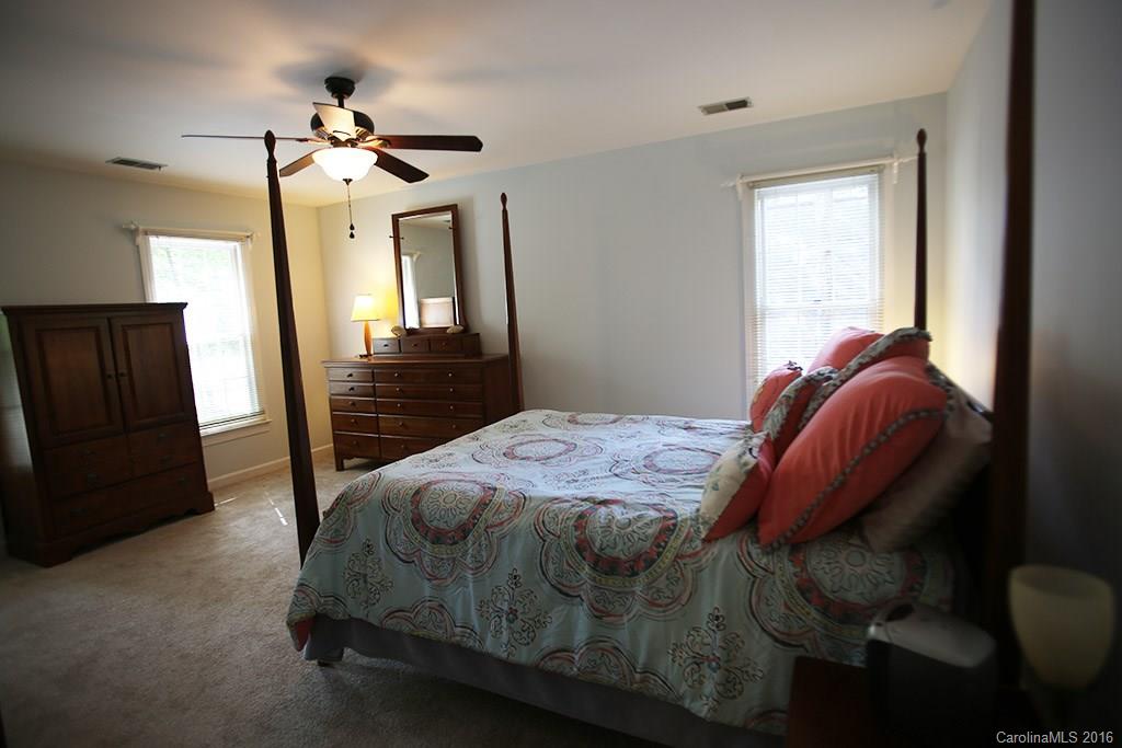 7226 Colony Road Charlotte, NC 28226 - Photo 9 of 24 a bedroom with a bed and a mirror
