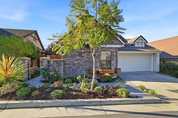 a front view of a house with a garden and yard