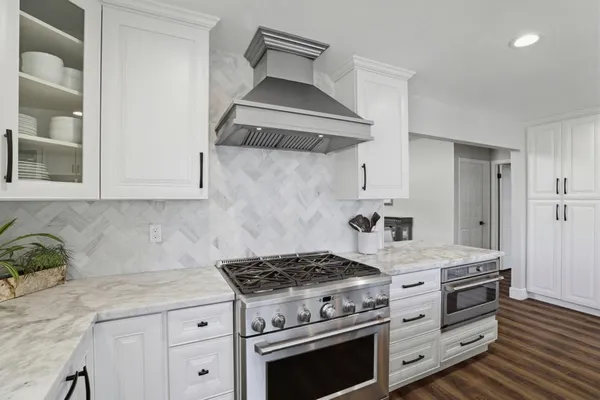 a kitchen with white cabinets and fireplace