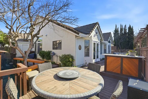 a backyard of a house with table and chairs plants