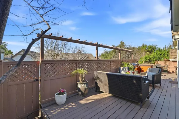 a view of a patio with table and chairs potted plants with floor to ceiling window and potted plants