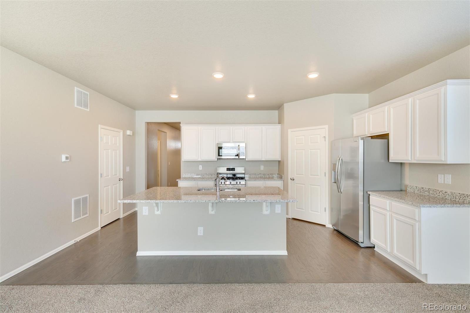 925 Camberly Drive Windsor, CO 80550 - Photo 11 of 29 a large kitchen with kitchen island a sink and a refrigerator