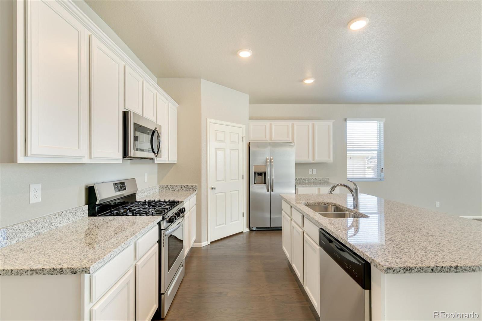 925 Camberly Drive Windsor, CO 80550 - Photo 13 of 29 a kitchen with stainless steel appliances granite countertop a sink stove and refrigerator