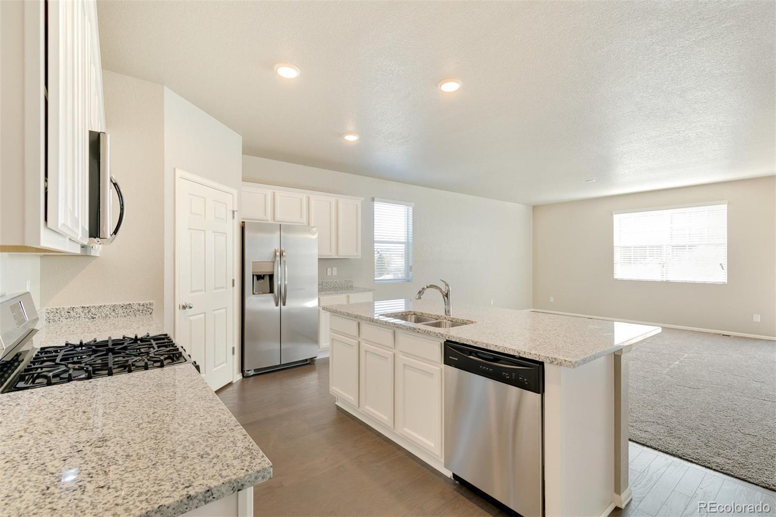 925 Camberly Drive Windsor, CO 80550 - Photo 14 of 29 a kitchen with white cabinets and stainless steel appliances