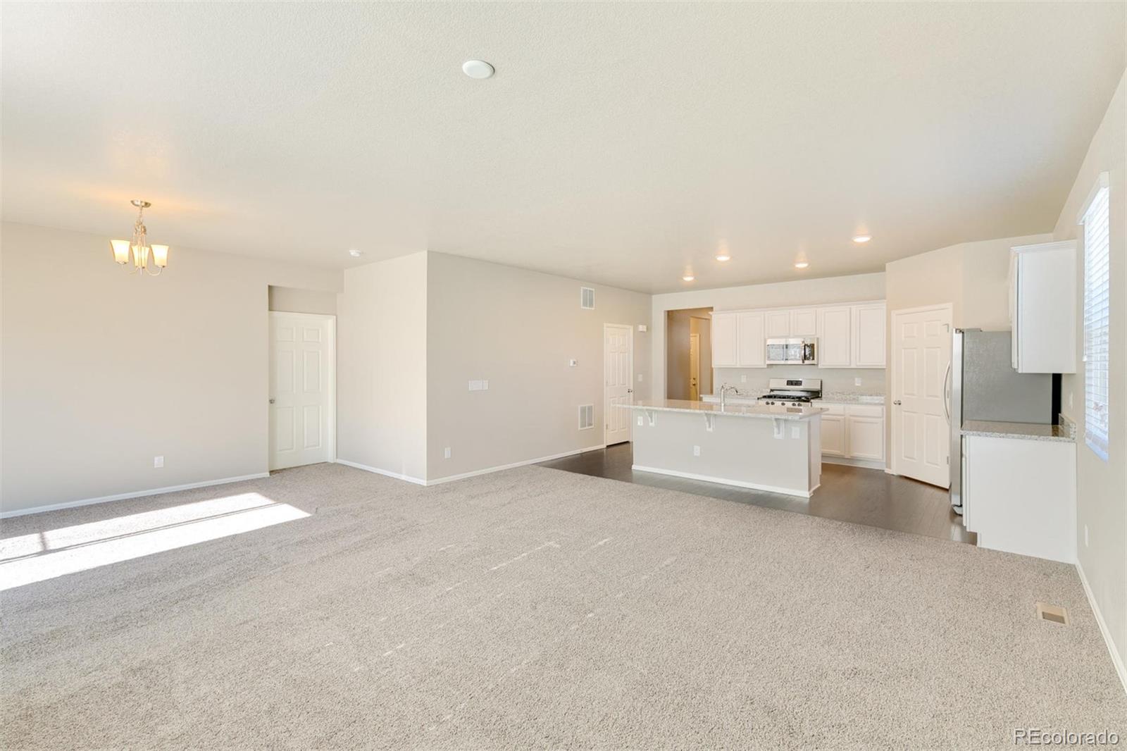 925 Camberly Drive Windsor, CO 80550 - Photo 5 of 29 a view of a kitchen with white cabinets and white appliances