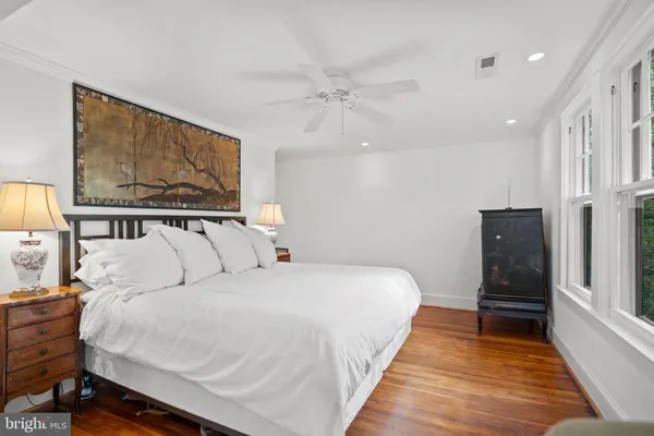 a room with a bed and large windows