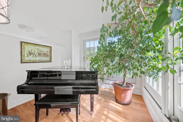 a living room with furniture a piano and a potted plant