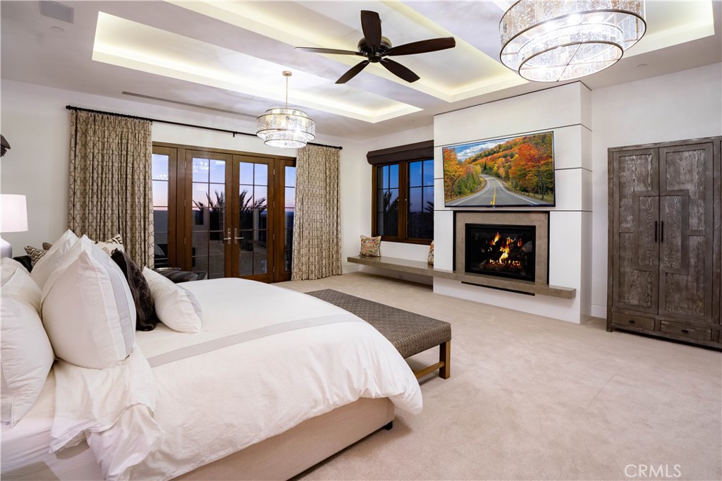 2 Thomas Road Ladera Ranch, CA 92694 - Photo 19 of 69 The primary suite is a serene sanctuary with its own balcony, a custom wood-paneled fireplace, motorized sunset shades and dual walk-in closets with built-ins.