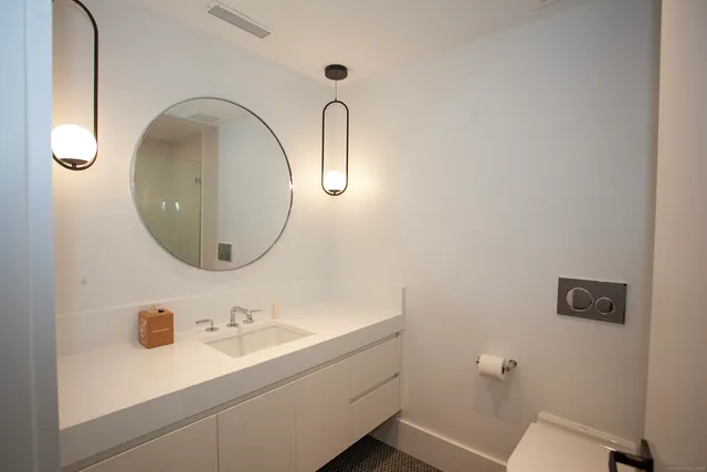 a dining hall with stainless steel appliances kitchen island granite countertop a table chairs and a refrigerator