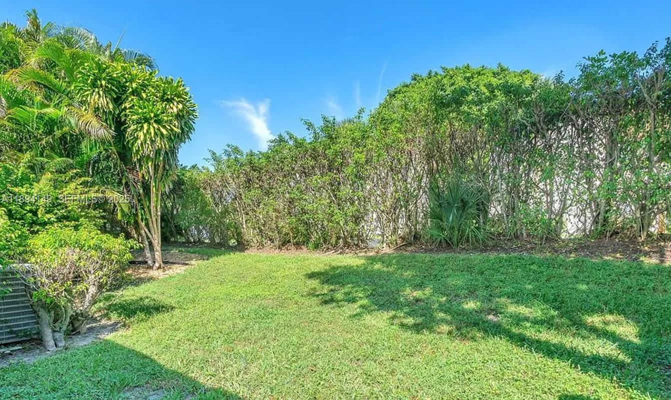 6850 Northwest 2nd Avenue, Unit 34 Boca Raton, FL 33487 - Photo 11 of 23 a grassy field with trees in the background