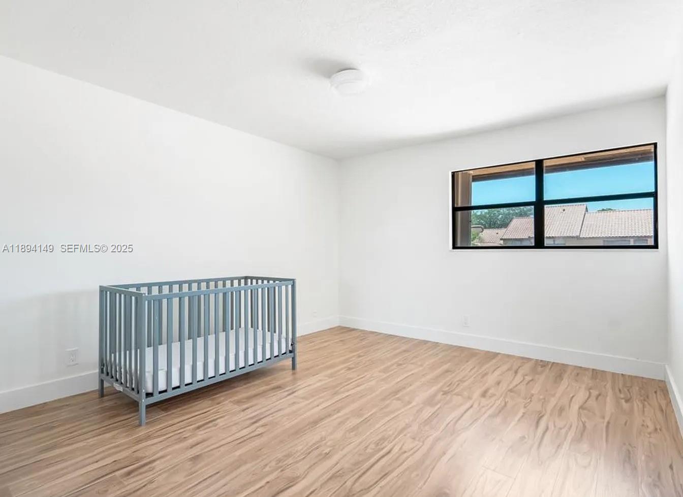 6850 Northwest 2nd Avenue, Unit 34 Boca Raton, FL 33487 - Photo 15 of 23 an empty room with wooden floor and windows
