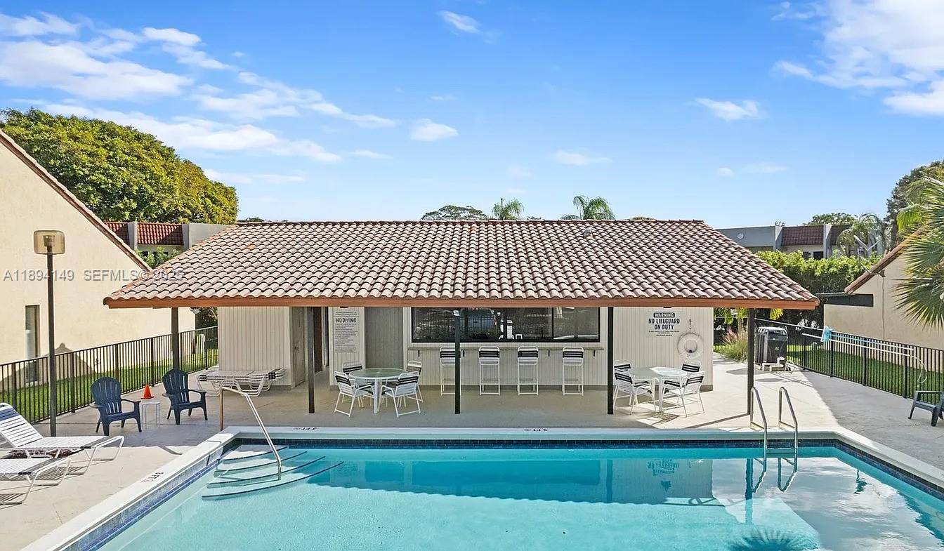 6850 Northwest 2nd Avenue, Unit 34 Boca Raton, FL 33487 - Photo 23 of 23 a front view of a house with a yard table and chairs